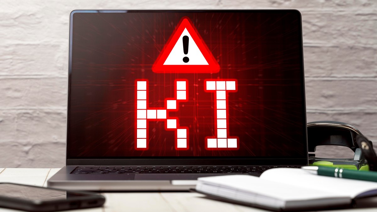 Symbolbild / Fotomontage: Warnung vor KI Künstlicher Intelligenz auf einem Laptop Computer Bildschirm in einem Büro 
