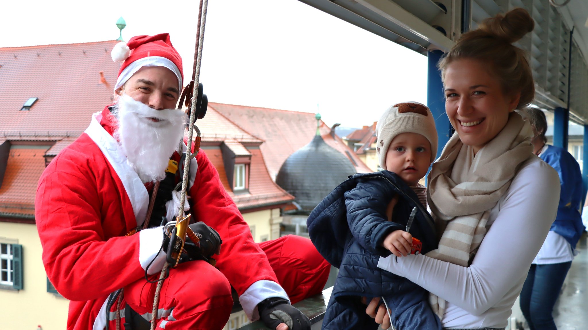 Höhenretter im Weihnachtsmann-Kostüm seilen sich an der Würzburger Uni-Kinderklinik ab. 