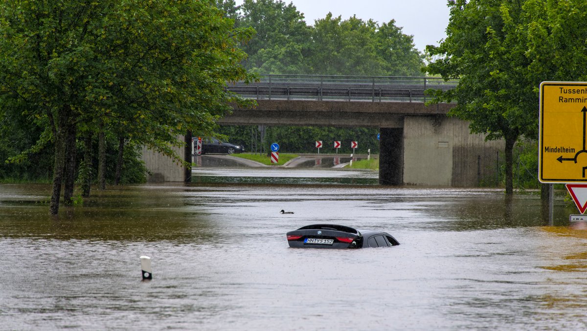Bad Wörishofen im Unterallgäu. Hochwasser nach andauernden Regenfällen, der Wörthbach hat die Unterführung der Autobahn A96 zum Skylinepark bei Kirchdorf überschwemmt. Ein Wagen ist steckengeblieben in den Fluten.