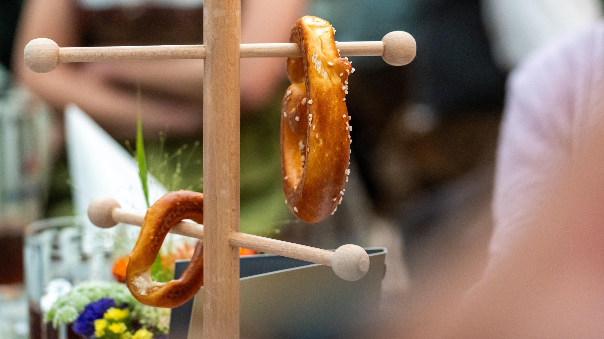 (Symbolbild) Frische Brezen auf einem Brezenständer im Armbrustschützenzelt - bei der Vorstellung des offiziellen Wiesn-Sammlerkrugs (Foto vom 28.08.2025) 
