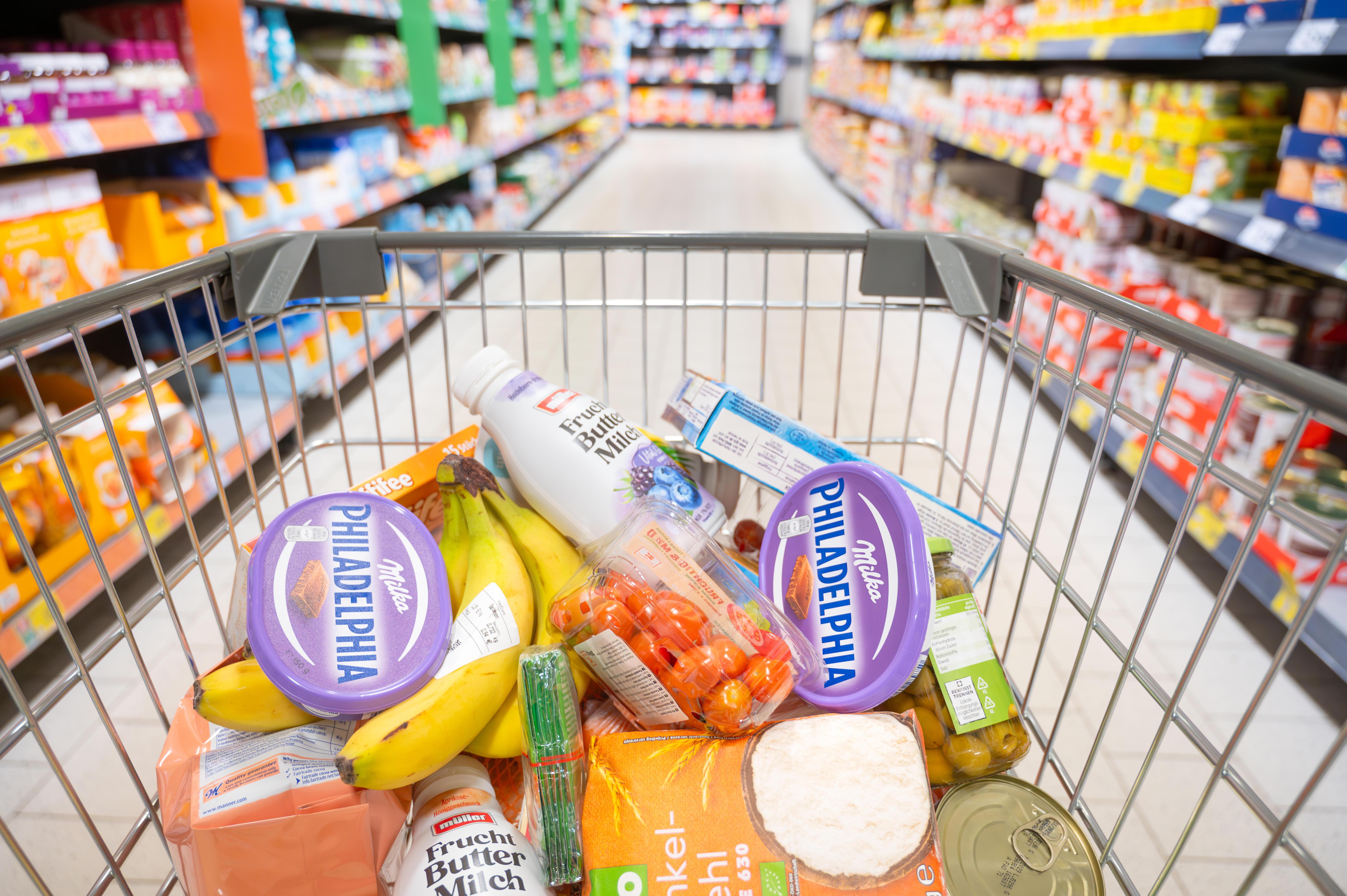 Einkaufswagen mit Lebensmitteln, darunter Buttermilch und Frischkäse
