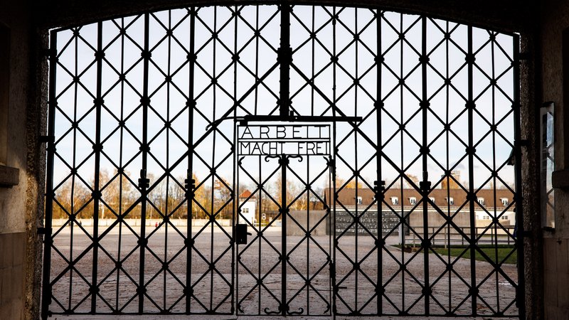 Die Inschrift "Arbeit macht frei" ist auf einem Tor am Eingang der KZ-Gedenkstätte Dachau zu sehen. | Bild: picture alliance/dpa | Matthias Balk Die Inschrift "Arbeit macht frei" ist auf einem Tor am Eingang der KZ-Gedenkstätte Dachau zu sehen.