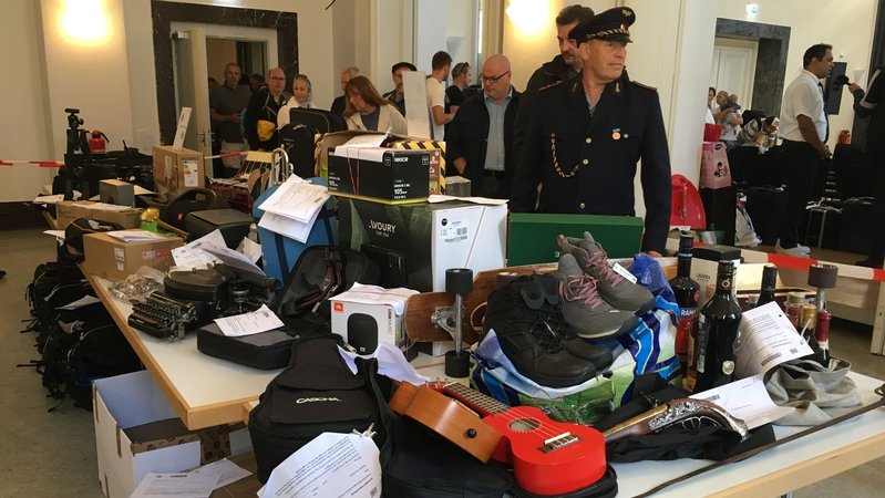 Menschen besichtigen kurz vor einer Versteigerung verschiedene Gegenstände auf Tischen. | Bild: BR24/Tobias Burkert Menschen besichtigen kurz vor einer Versteigerung verschiedene Gegenstände auf Tischen.