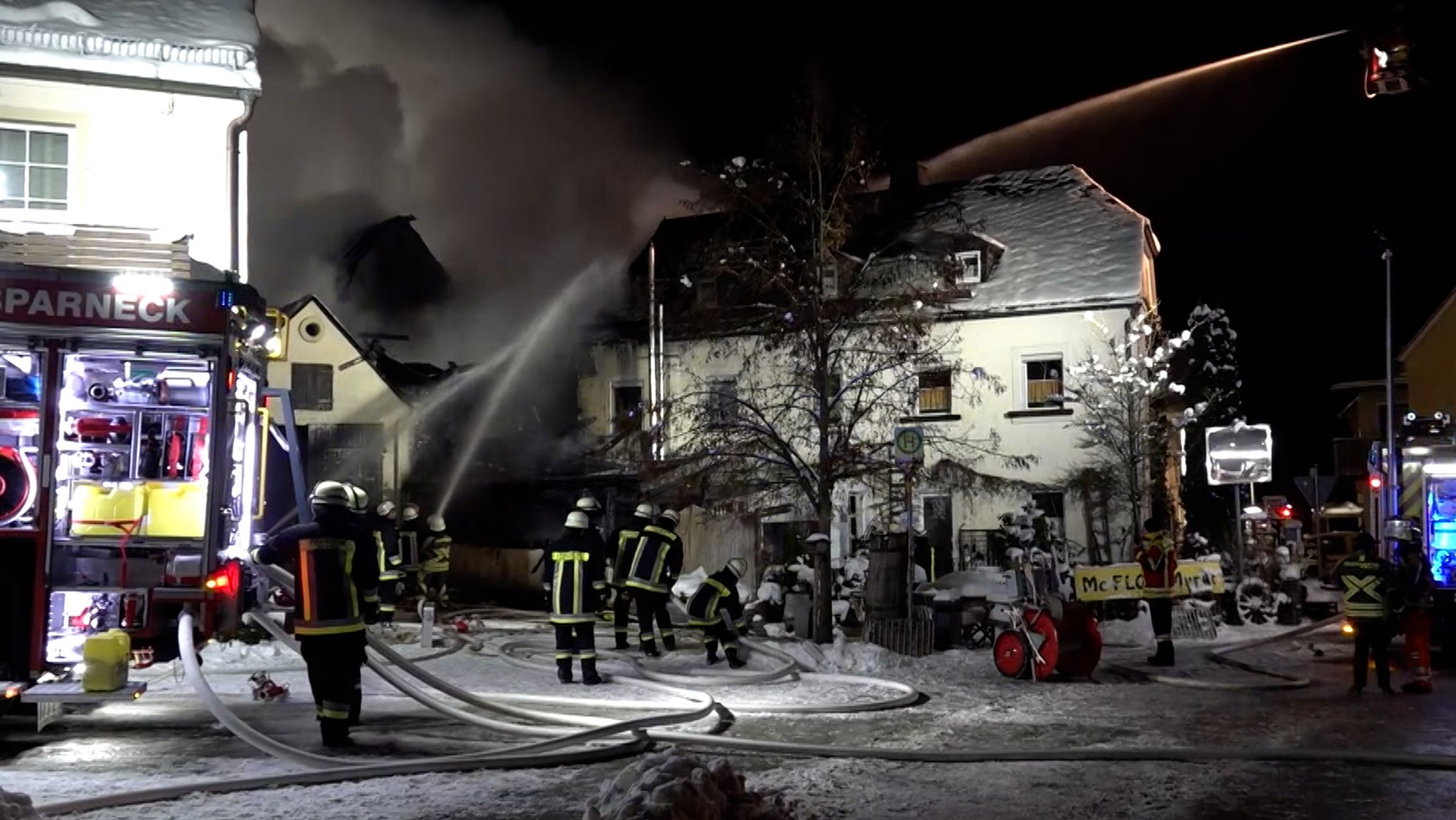 Feuerwehrleute löschen nachts einen Brand.