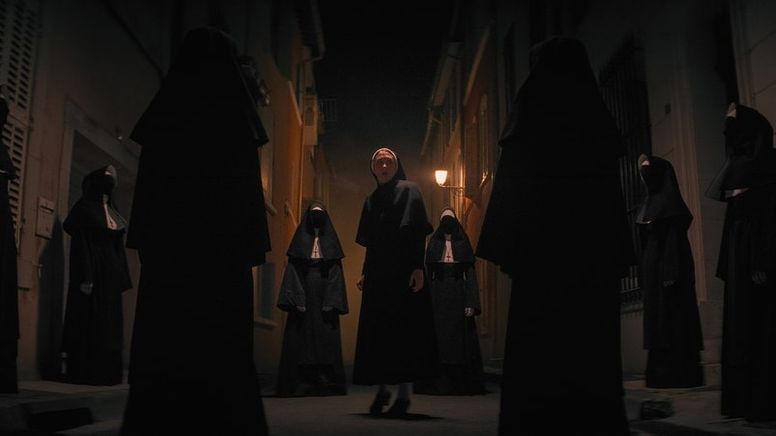 Mehrere schwarz gekleidete Nonnen umzingeln eine erscheckt blickende junge Nonne | Bild:TM & © 2023 Warner Bros. Entertainment Inc. Alle Rechte vorbehalten.