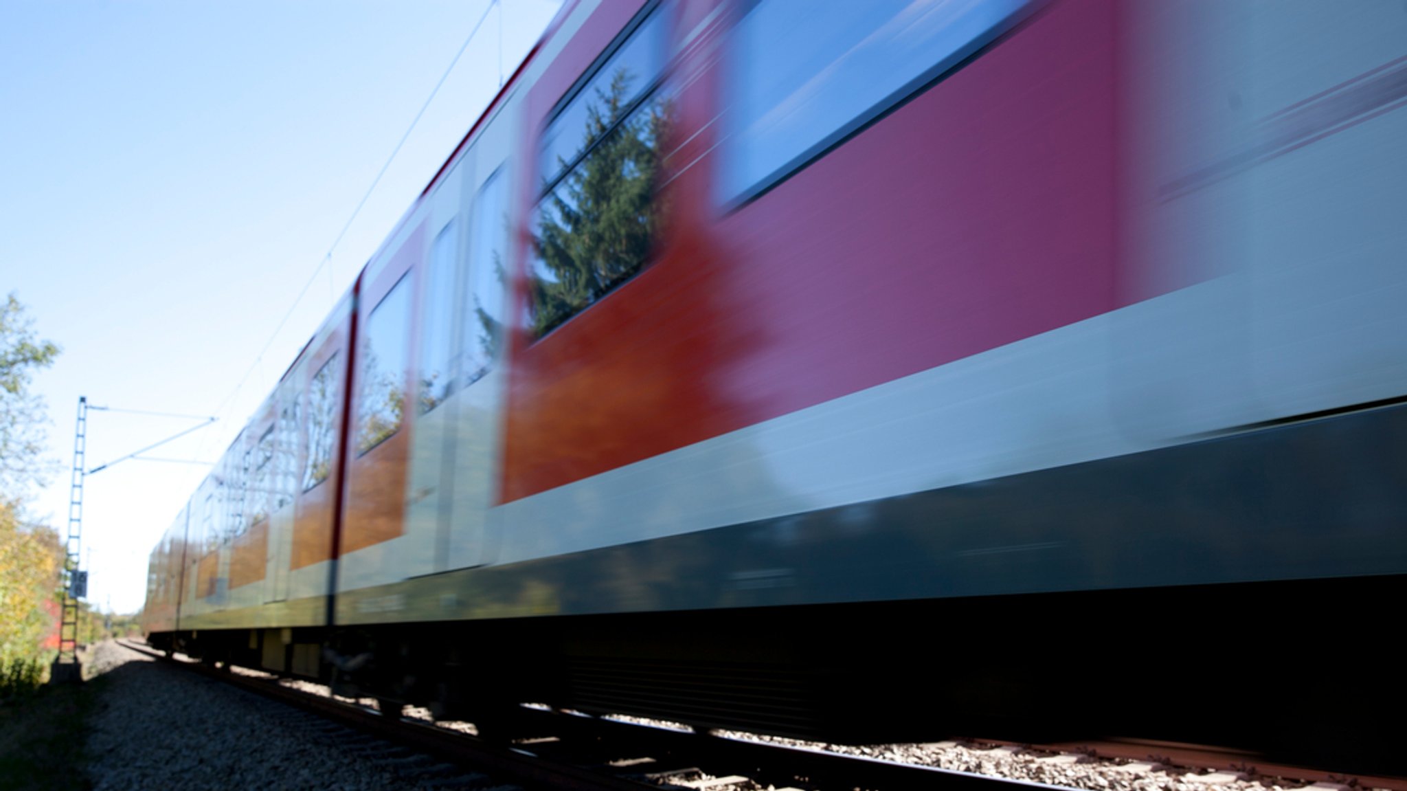 Ein Regionalzug der Bahn, im Hintergrund ein Oberleitungsmast (Symbolbild).