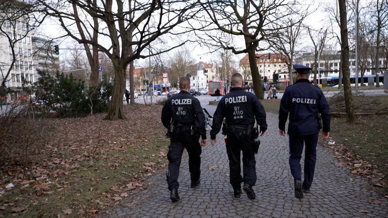 Polizisten laufen durch einen Park in Regensburg