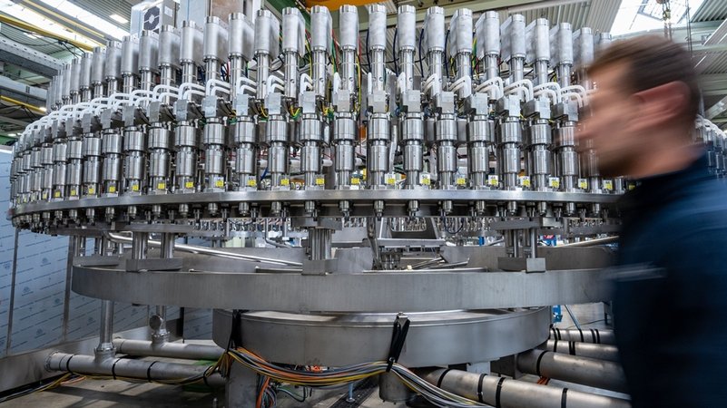 Ein Mitarbeiter geht an einer Abfüllanlage in der Produktion eines Maschinenbauunternehmens vorbei | Bild: dpa-Bildfunk/Armin Weigel Ein Mitarbeiter geht an einer Abfüllanlage in der Produktion eines Maschinenbauunternehmens vorbei