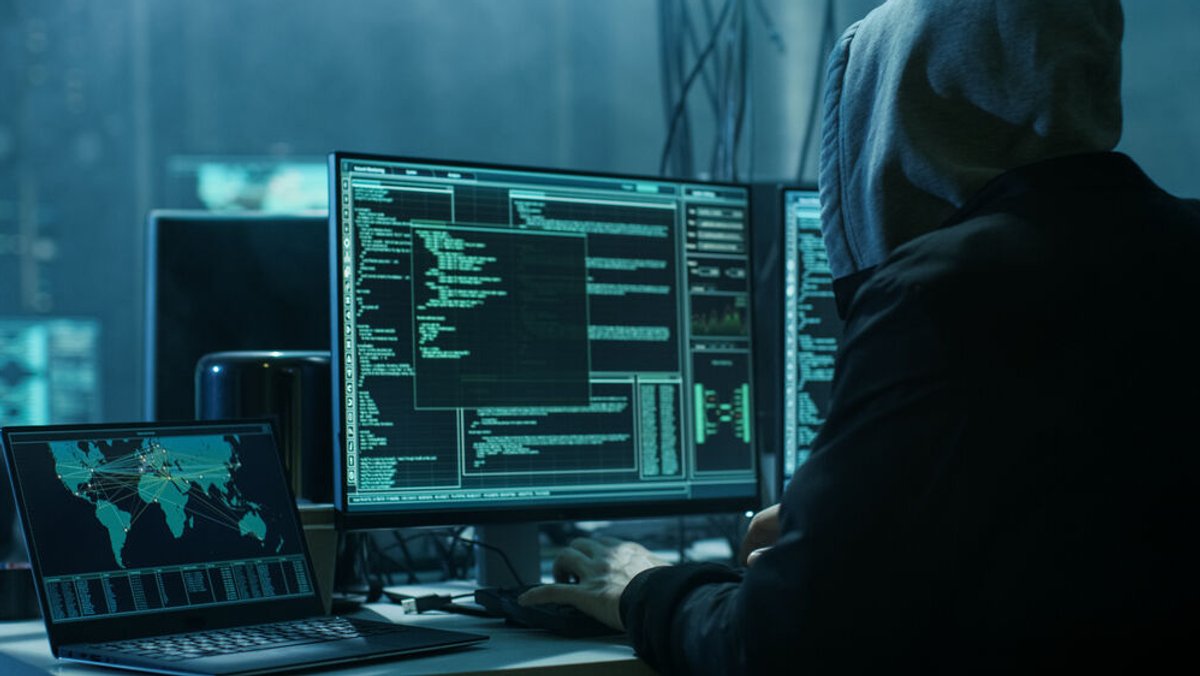 Ein Mann sitzt vor einem Computer und hackt (Symbolbild)