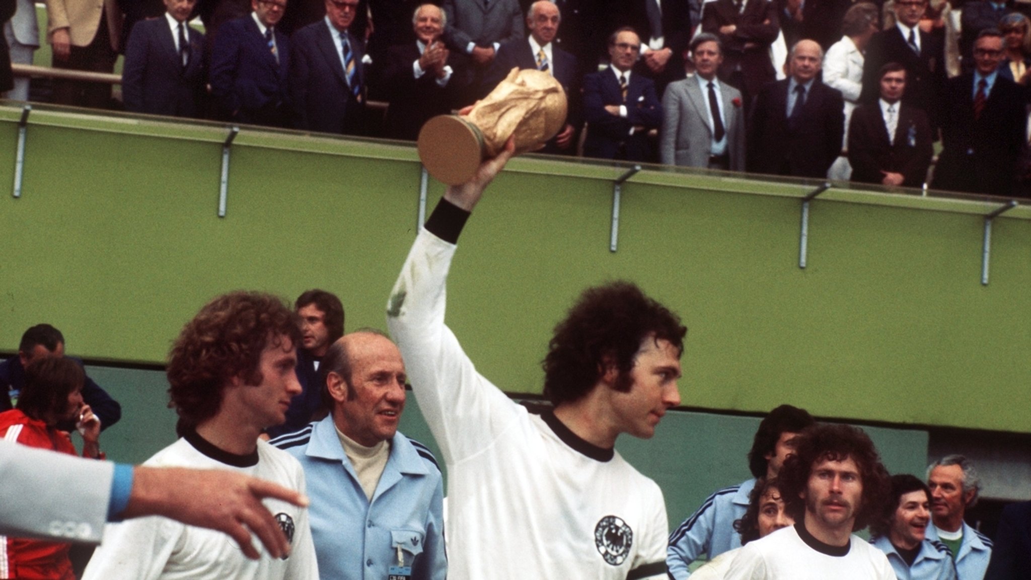 Franz Beckenbauer (M) hält den WM-Pokal hoch