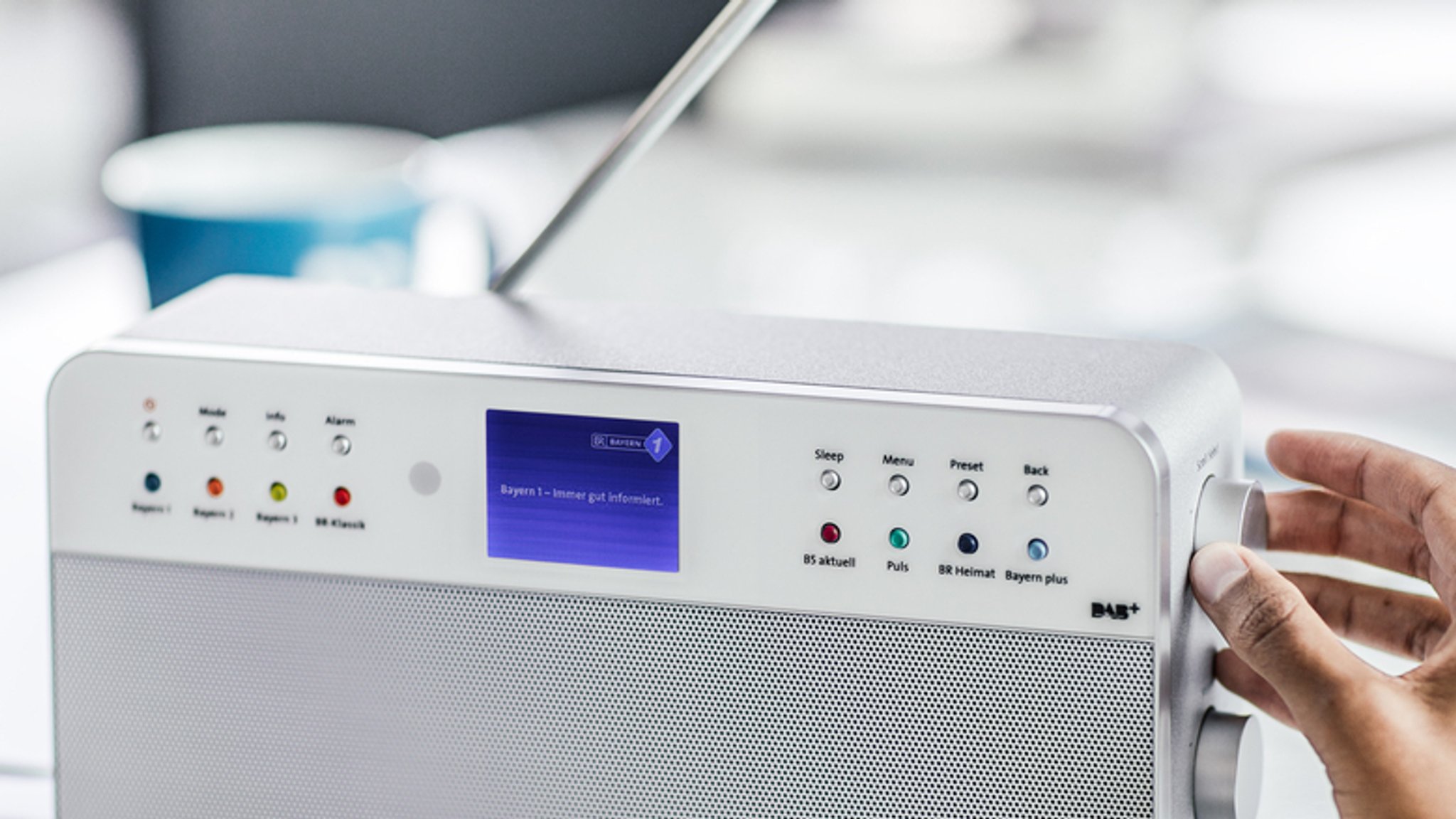 Eine Frau bedient ein DAB-Radio.