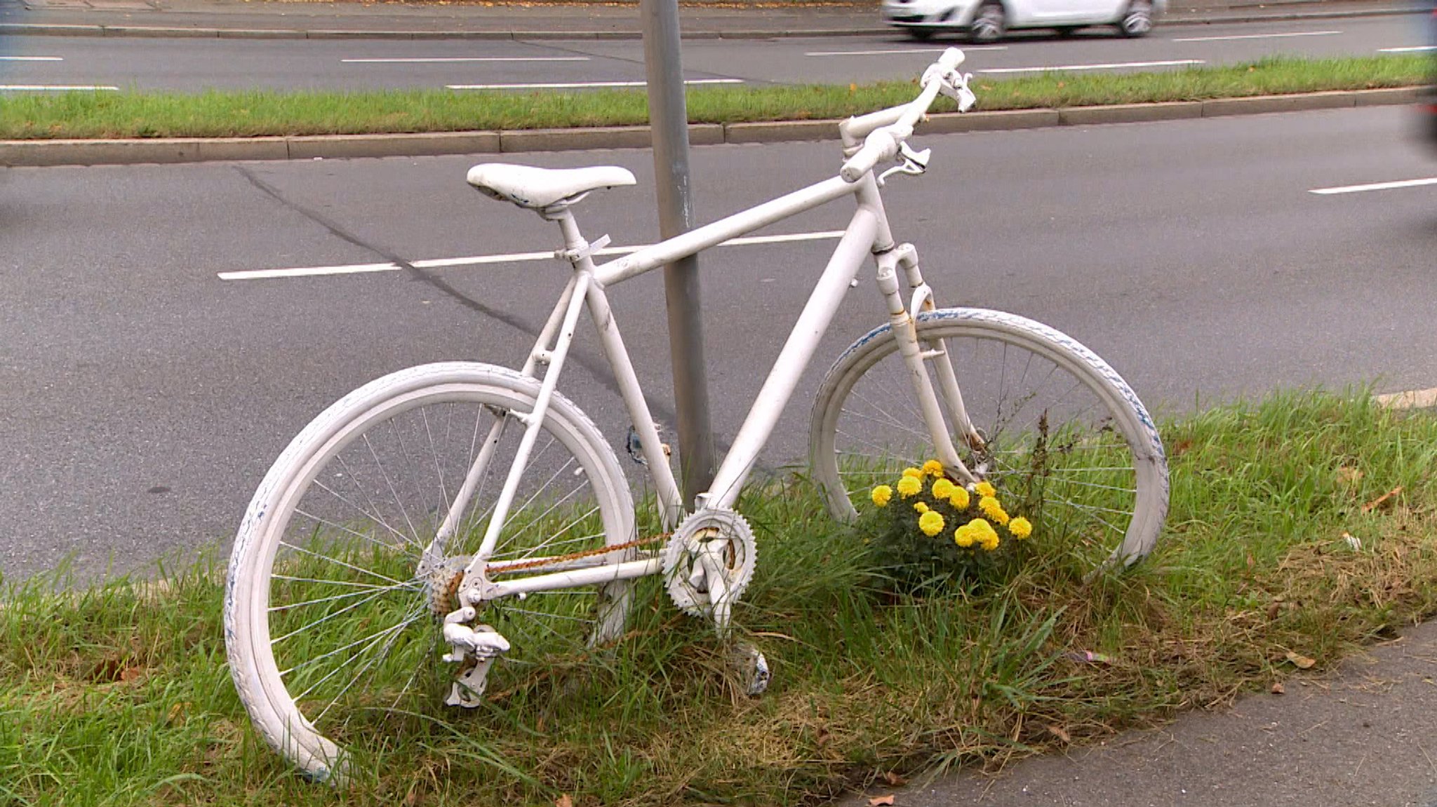 Ein weißes Fahrrad am Straßenrand