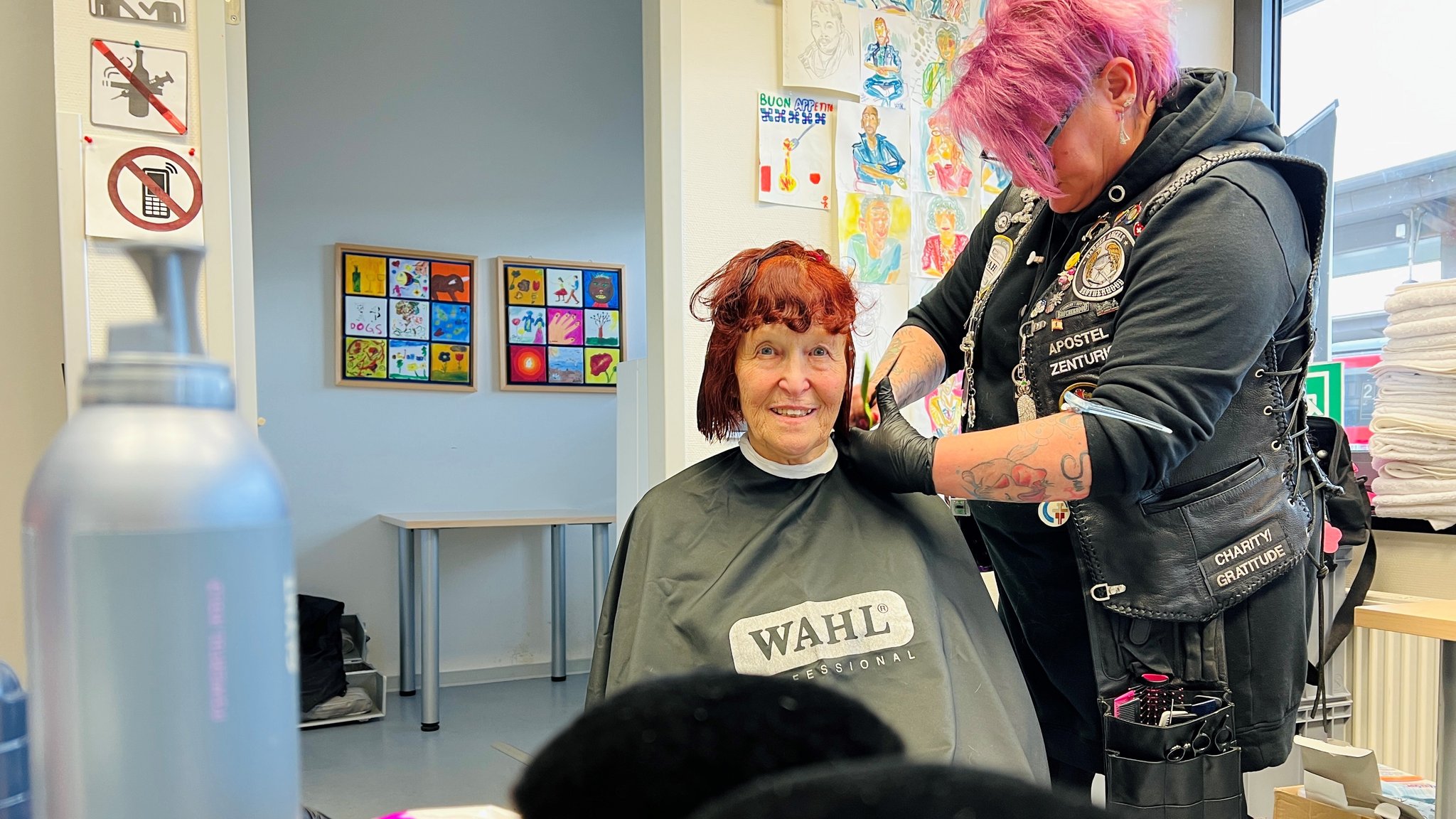 Eine Frau von den Barber Angels beim Haareschneiden in der Bahnhofsmission Aschaffenburg.