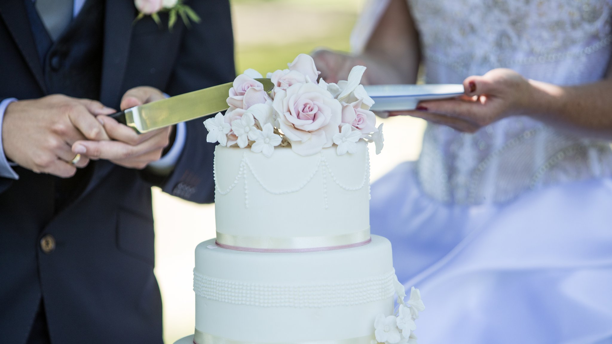 Ein frisch verheiratetes Paar schneidet eine Hochzeitstorte an