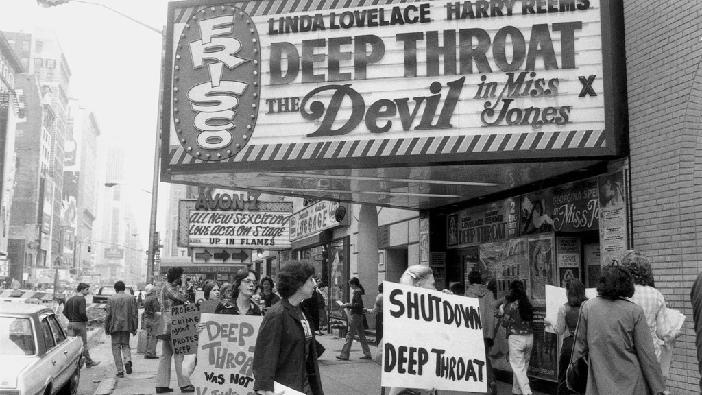 Schwarz-weiß Bild: Frauenrechtlerin protestieren mit Transparenten gegen "Deep Throat" vor einem Kino, in dem der Film gezeigt wird