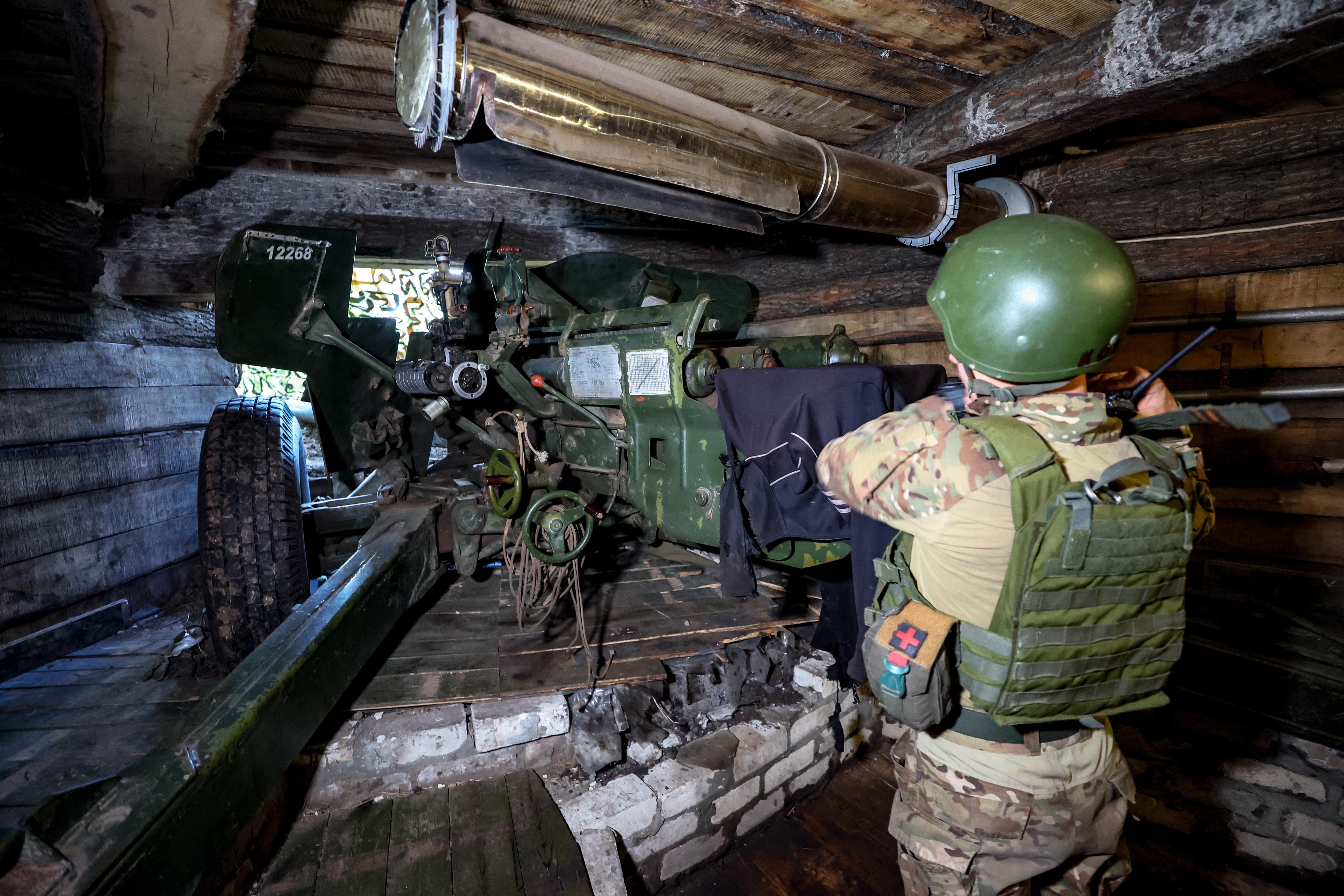 Ein Mann in Kampfmontur am Artilleriegeschütz