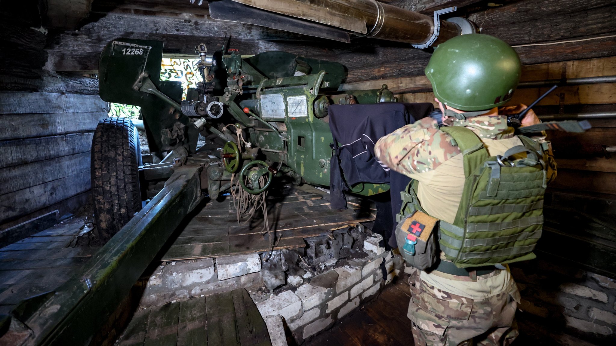 Ein Mann in Kampfmontur am Artilleriegeschütz