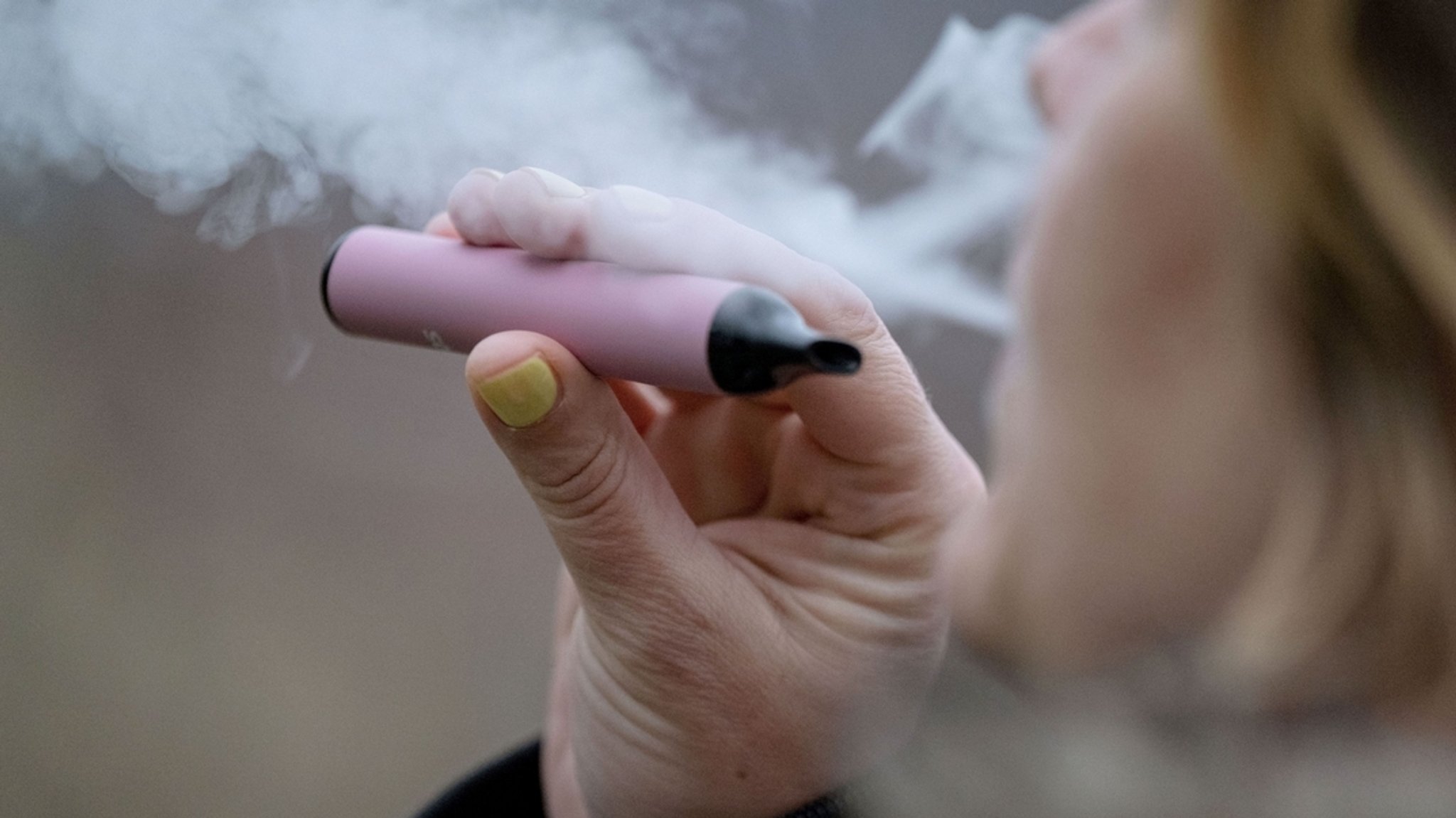 (Symbolbild) Eine Frau raucht eine E-Zigarette.