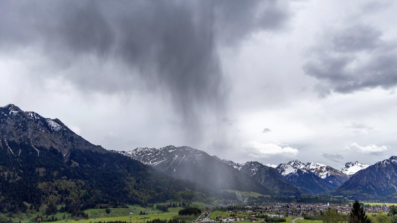 02.05.2024: Dunkle Wolken und Fallstreifen eines Schauers sind über Oberstdorf im Allgäu zu sehen, der DWD erwartet auch heute heftigen Regenfälle.