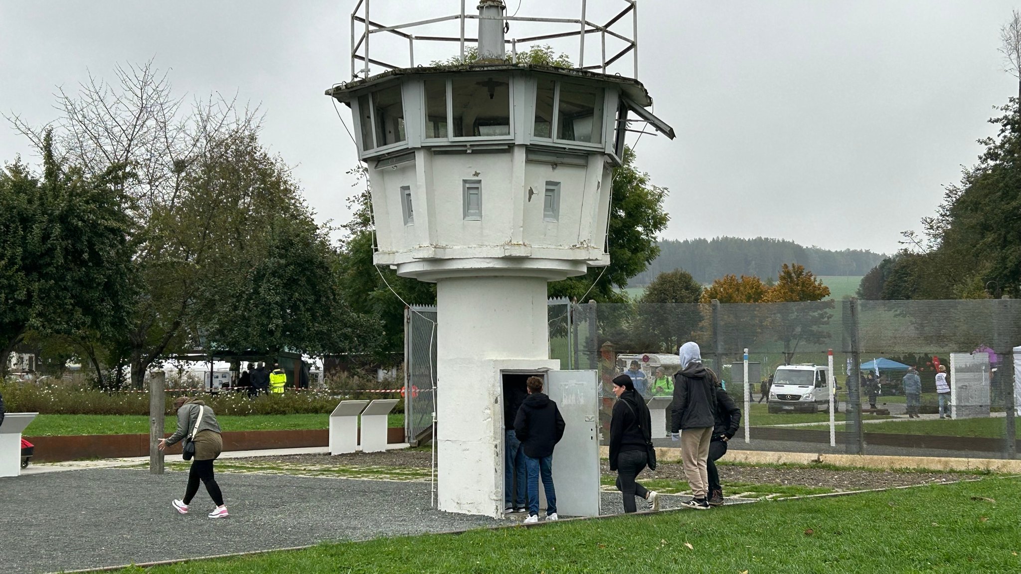 Menschen stehen vor einem Wachturm.