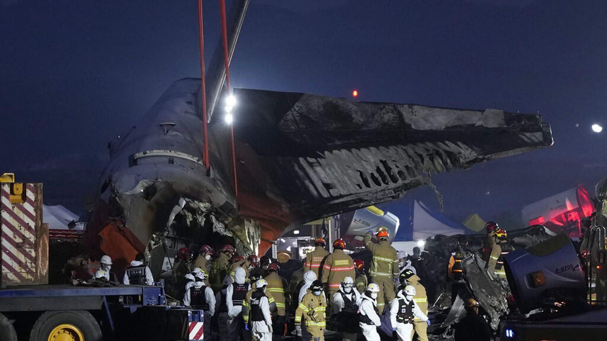 dpatopbilder - 29.12.2024, Südkorea, Muan: Rettungskräfte tragen die Leiche eines Passagiers. Bei der Landung am internationalen Flughafen von Muan in Südkorea ist ein Passagierflugzeug verunglückt. Foto: Ahn Young-joon/AP/dpa +++ dpa-Bildfunk +++