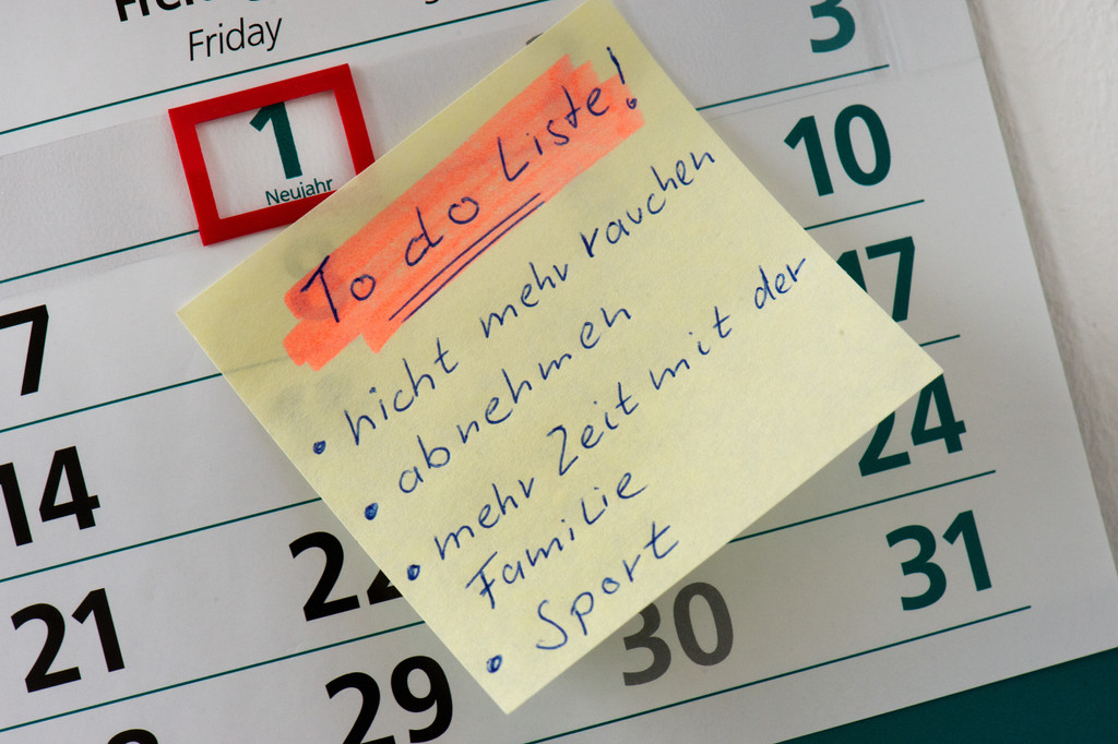 Zettel mit  "To do Liste" auf dem 1. Januar eines Kalenders mit den Vorsätzen "nicht mehr rauchen, abnehmen, mehr Zeit mit der Familie und Sport".