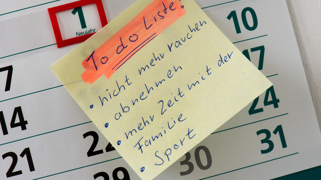 Zettel mit  "To do Liste" auf dem 1. Januar eines Kalenders mit den Vorsätzen "nicht mehr rauchen, abnehmen, mehr Zeit mit der Familie und Sport".