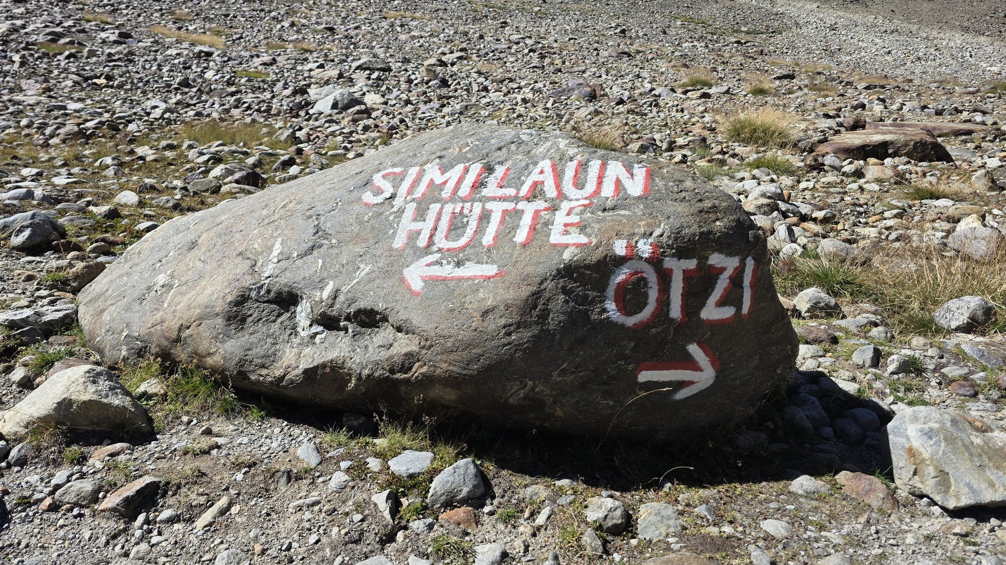 Auf einen Felsbrocken ist ein Wegweiser zur Ötzi-Fundstelle aufgemalt. | Bild: BR/Ulrike Nikola Auf einen Felsbrocken ist ein Wegweiser zur Ötzi-Fundstelle aufgemalt.