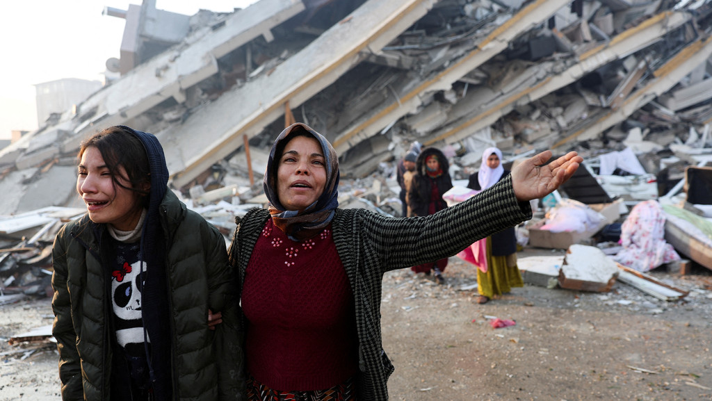Frauen vor einem zerstörten Haus in Hatay, Türkei