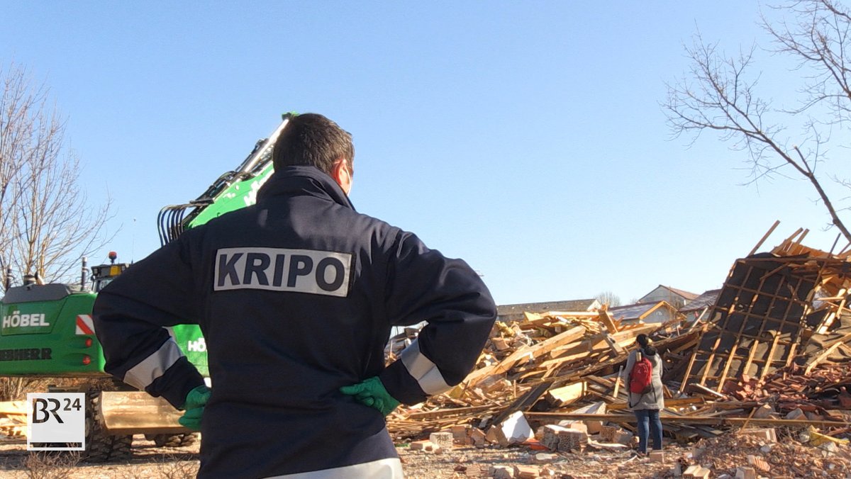 Ein Kripo-Beamter steht vor dem zerstörten Vereinsheim in Kaufbeuren
