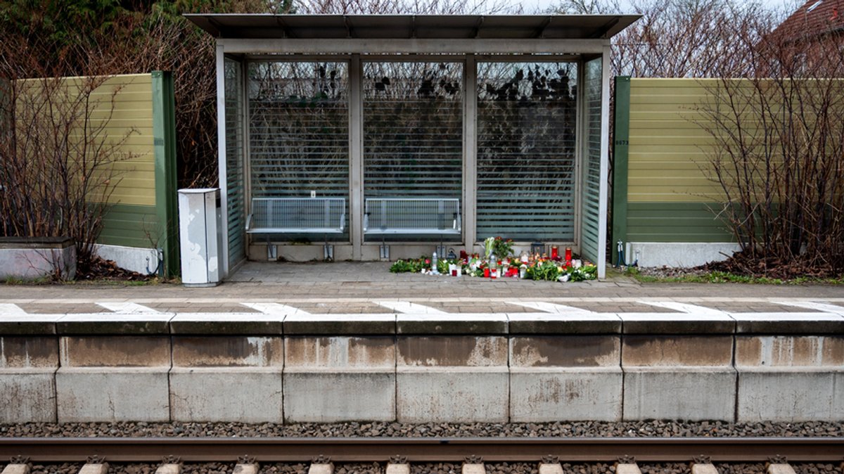Kerzen und Blumen stehen und liegen im Bahnhof Brokstedt in einem Wartehäuschen. Bei einer Messerattacke in einem Regionalzug von Kiel nach Hamburg waren am 25.01.2023 in Brokstedt zwei junge Menschen getötet und fünf verletzt worden. (Archivbild)