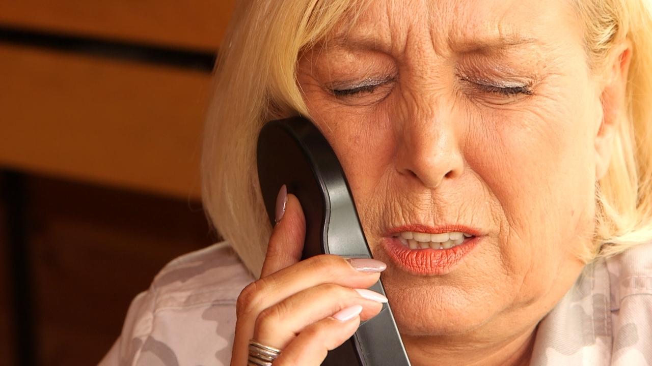 Frau hält sich einen Nervenstimulator an die Wangerzen