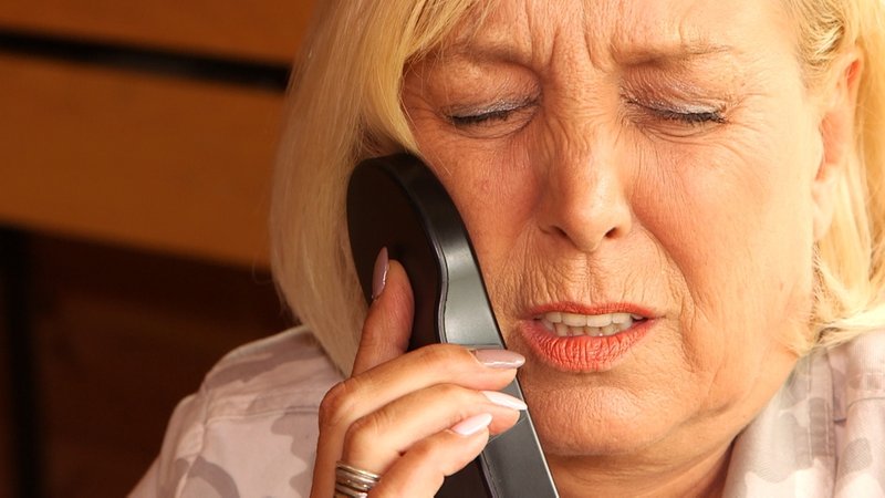 Frau hält sich einen Nervenstimulator an die Wangerzen | Bild: Screenshot BR Frau hält sich einen Nervenstimulator an die Wangerzen