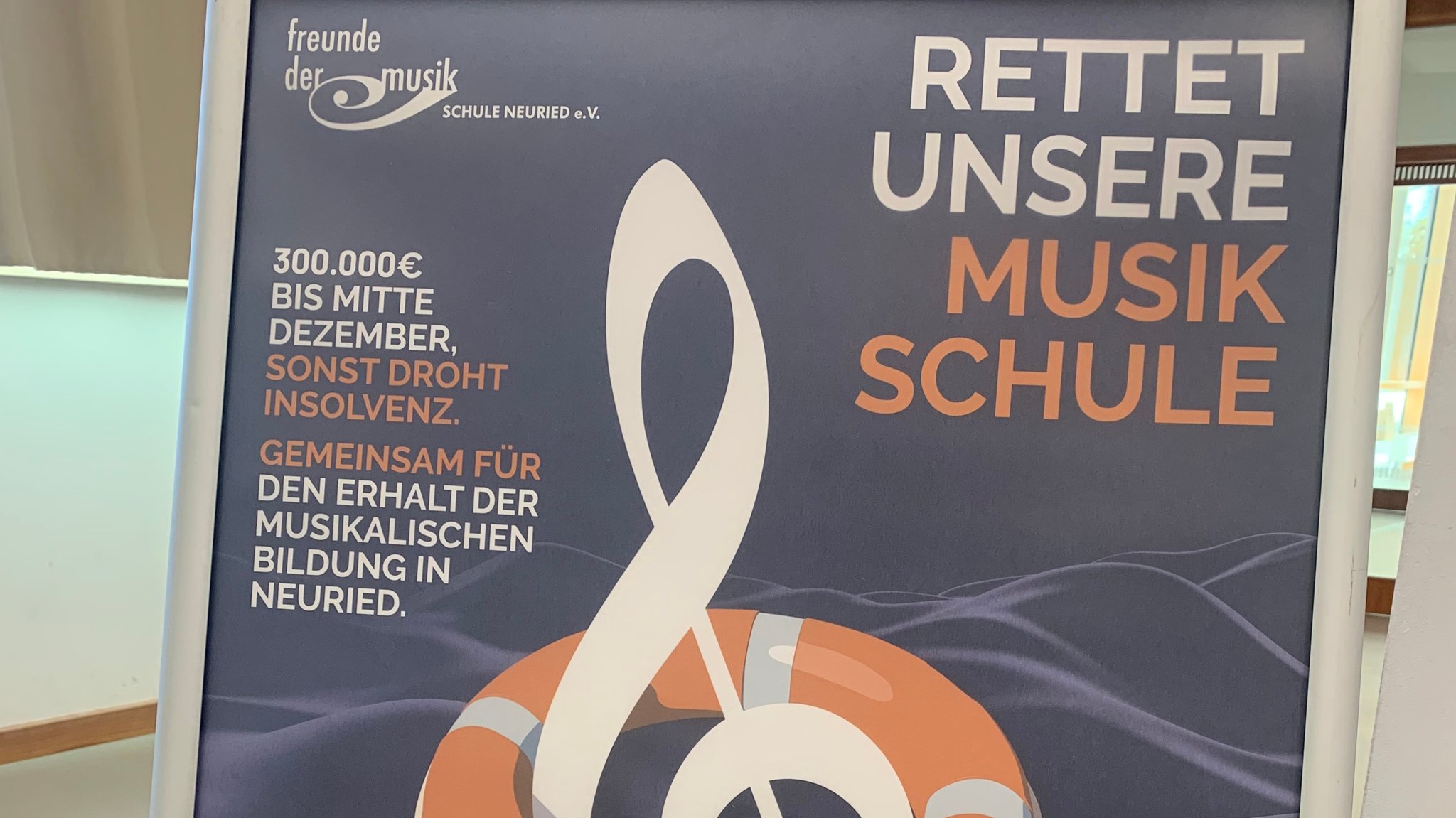 Plakat mit der Aufschrift: Rettet undsere Musikschule. 300.000 Euro bis Mitte Dezember, sonst drohn Insolvenz. Gemeinsam für den Erhalt der musikalischen Bildung in Neuried. Freunde der Musikschule Neuried e.V.. | Bild: BR / Hans-Joachim Vieweger Plakat mit der Aufschrift: Rettet undsere Musikschule. 300.000 Euro bis Mitte Dezember, sonst drohn Insolvenz. Gemeinsam für den Erhalt der musikalischen Bildung in Neuried. Freunde der Musikschule Neuried e.V..