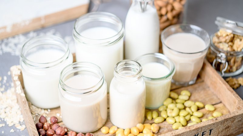 Verschiedene Gläser mit Ersatz-Milch auf einem Tablett und verschiedene Zutaten wie Mandeln, Nüsse, Erbsen. | Bild: picture alliance / dpa Themendienst | Zacharie Scheuer Verschiedene Gläser mit Ersatz-Milch auf einem Tablett und verschiedene Zutaten wie Mandeln, Nüsse, Erbsen.