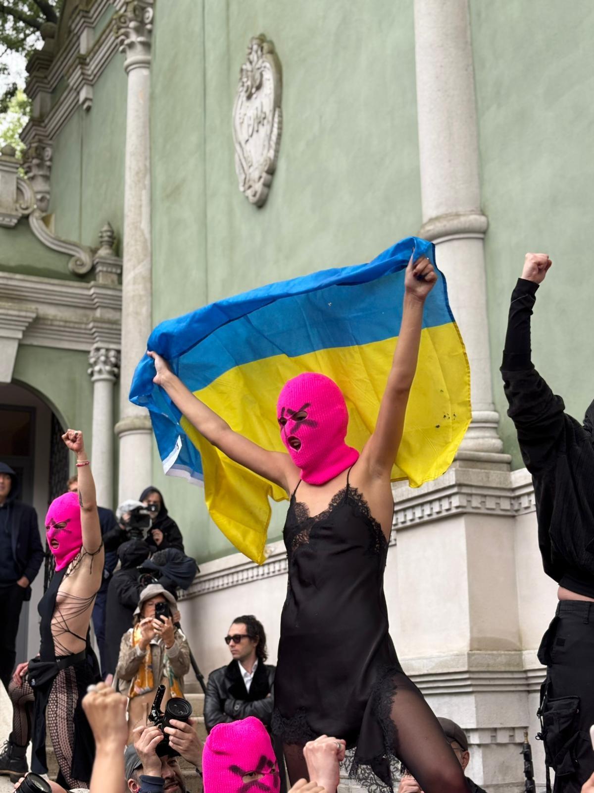 Ein Mitglied des Punk-Kollektivs "Pussy Riot" mit pinker Sturmhaube und Ukraine-Flagge
