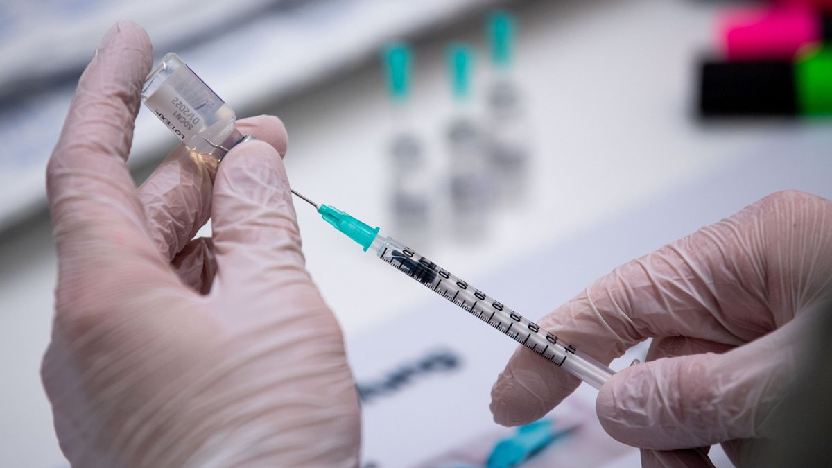 ARCHIV - 13.11.2021, Niedersachsen, Osnabrück: Eine Person bereitet Biontech-Impf-Dosen vor.