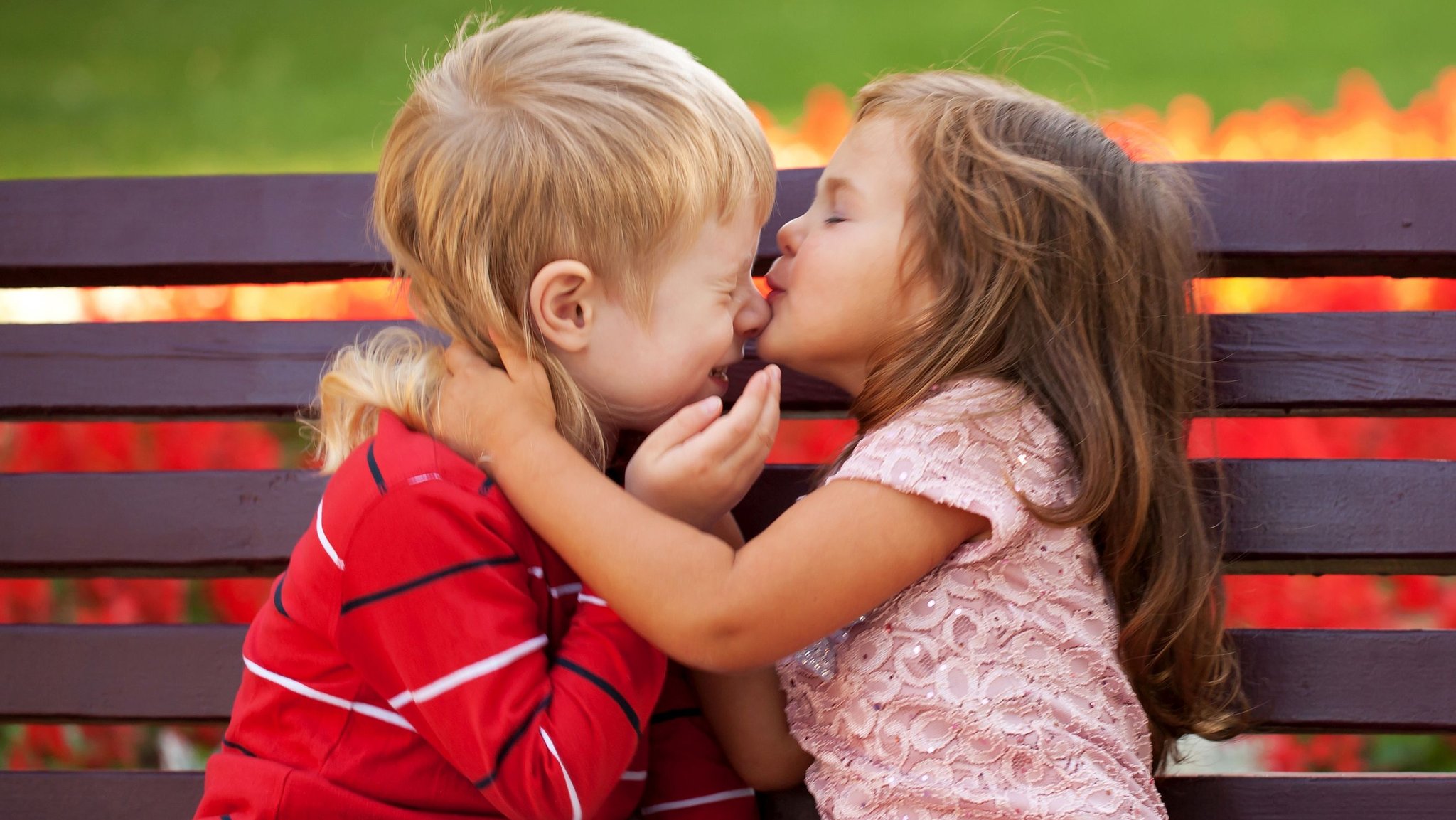 Zwei sich umarmende Kinder auf einer Bank