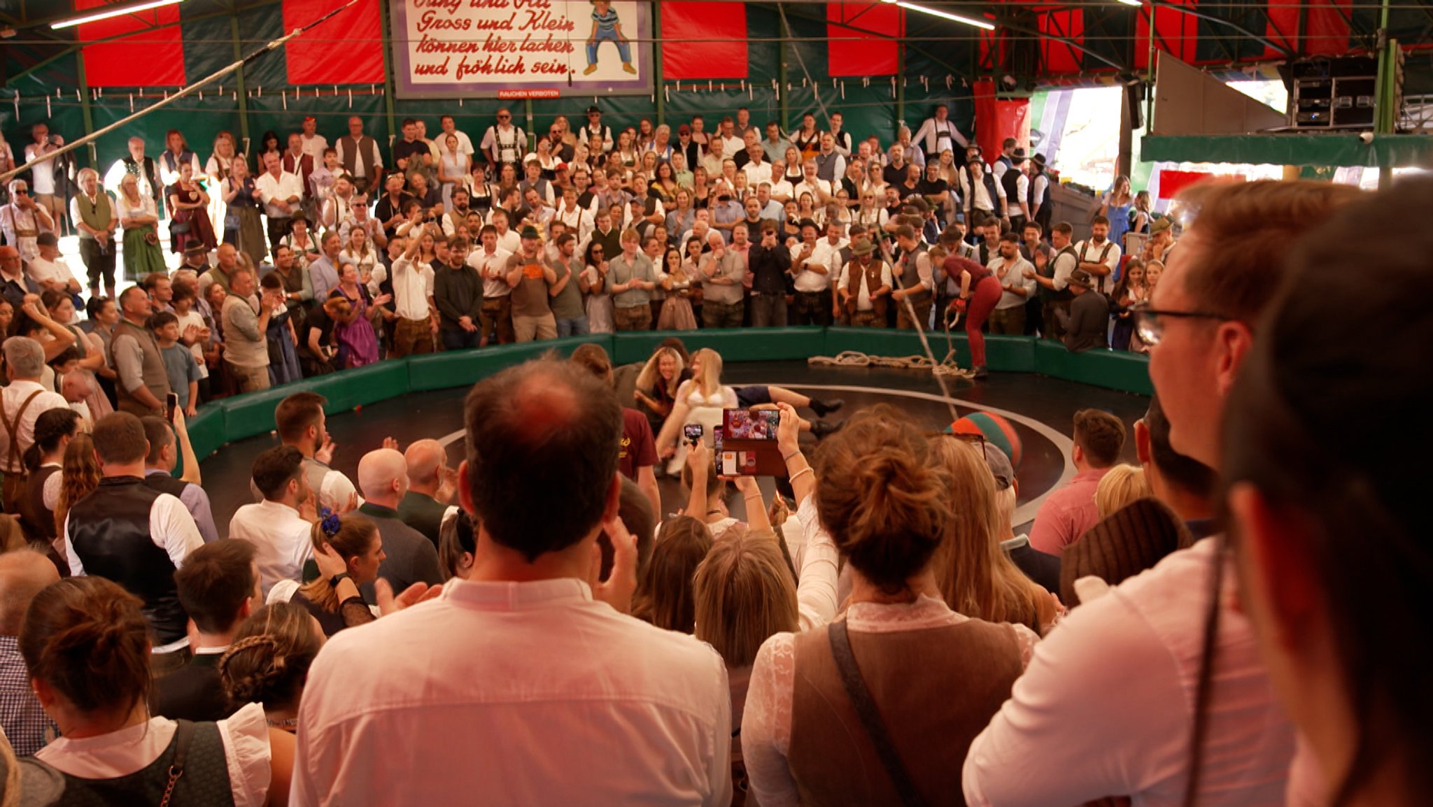 Wenn sich derzeit auf der Wiesn das Teufelsrad dreht, kocht die Stimmung. Doch einige Handybesitzer filmen dabei mit, nicht selten auch Frauen unters Dirndl. Die Aufnahmen landen im Netz und versprechen dort ein Riesengeschäft, wie BR-Recherchen zeigen. | Bild: Bayerischer Rundfunk 2026 Wenn sich derzeit auf der Wiesn das Teufelsrad dreht, kocht die Stimmung. Doch einige Handybesitzer filmen dabei mit, nicht selten auch Frauen unters Dirndl. Die Aufnahmen landen im Netz und versprechen dort ein Riesengeschäft, wie BR-Recherchen zeigen.