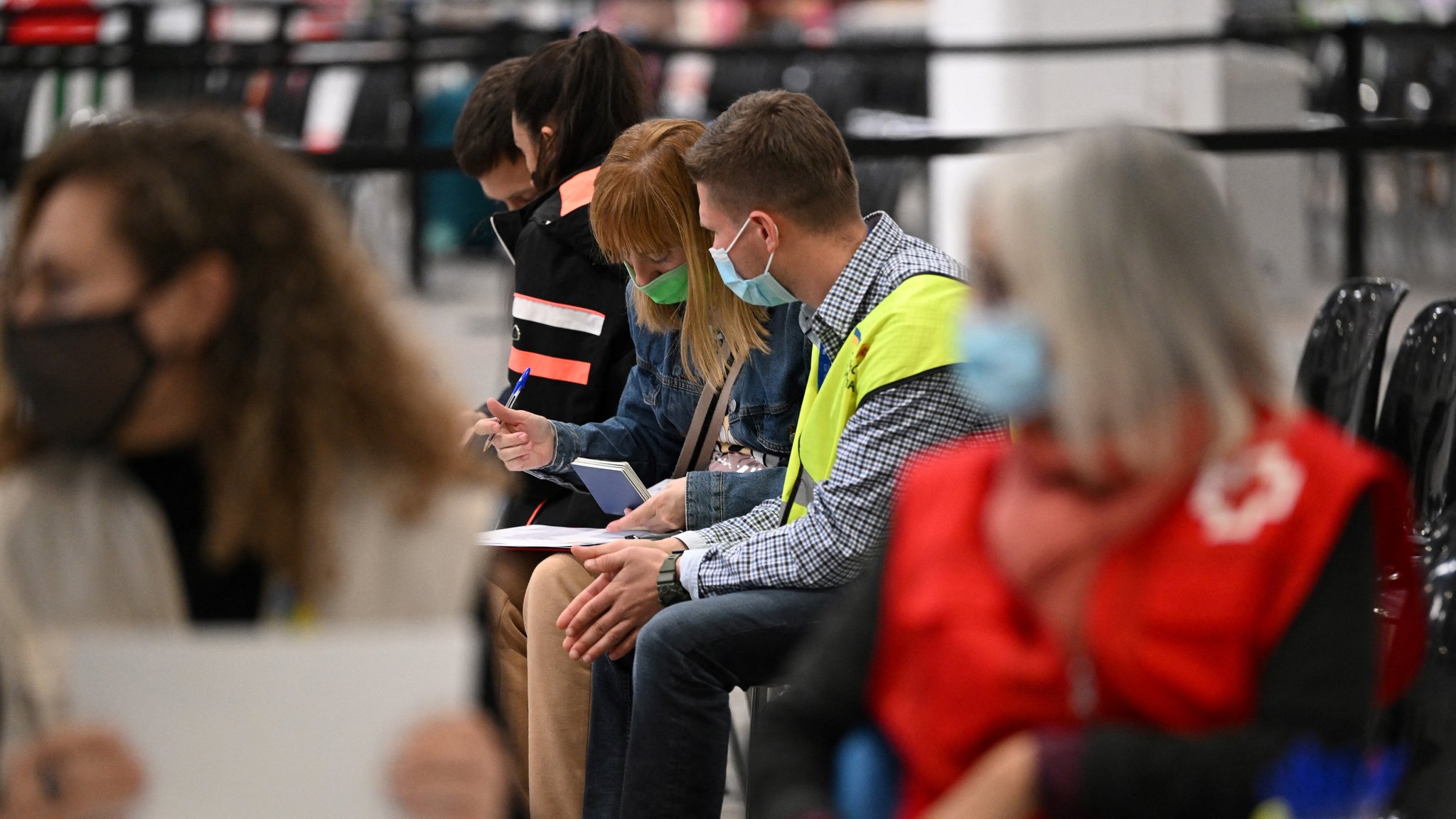 Mitglieder des Spanischen Roten Kreuzes helfen Menschen bei der Ankunft in einem Aufnahmezentrum für ukrainische Flüchtlinge an dem Messegelände Fira in Barcelona, am 8. April 2022