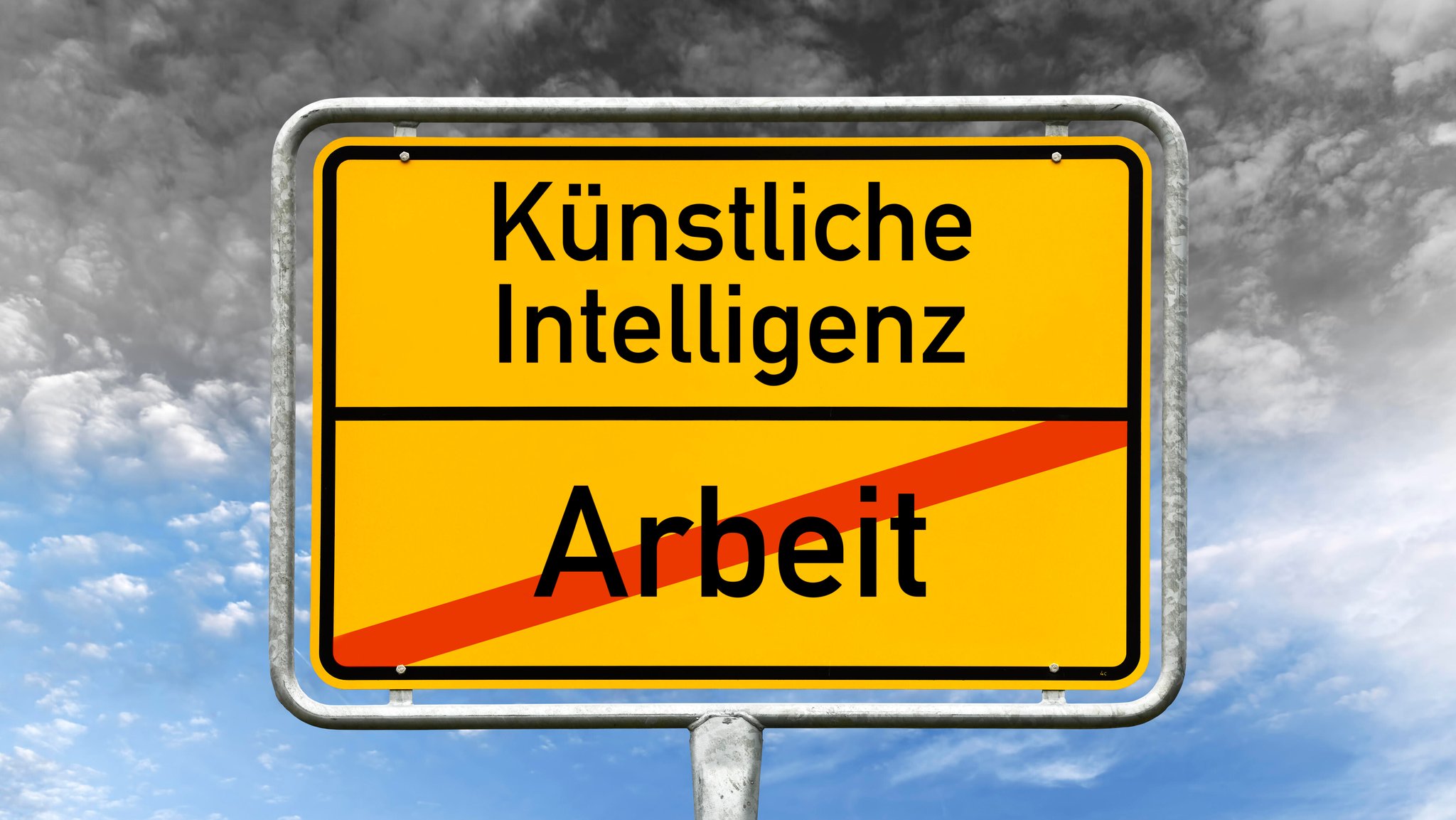 (Symbolbild) Ein Ortsschild, auf dem das Wort "Arbeit" durchgestrichen ist. Darüber steht "Künstliche Intelligenz".