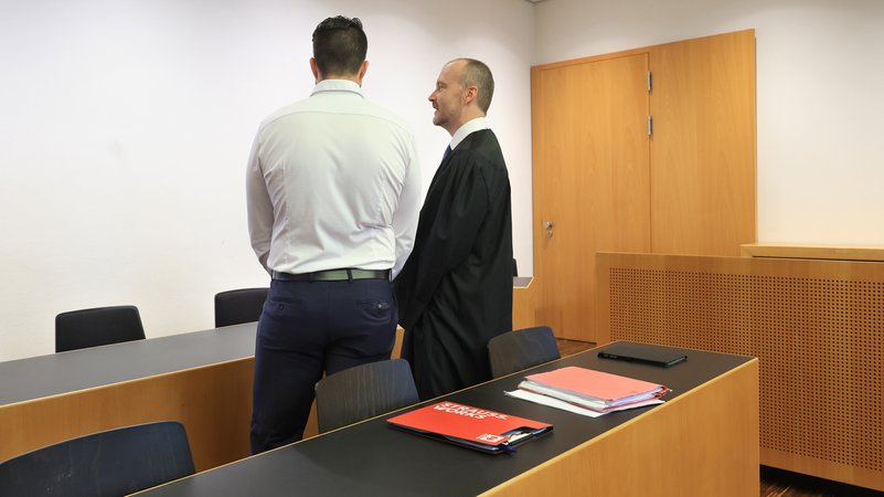 Der Polizist, der wegen des Schusses beim FCA-Stadion verurteilt worden ist, steht mit dem Rücken zur Kamera am 20.8.24 im Gerichtssaal im Landgericht Augsburg neben seinem Anwalt. | Bild: picture alliance/dpa/Karl-Josef Hildenbrand Der Polizist, der wegen des Schusses beim FCA-Stadion verurteilt worden ist, steht mit dem Rücken zur Kamera am 20.8.24 im Gerichtssaal im Landgericht Augsburg neben seinem Anwalt.