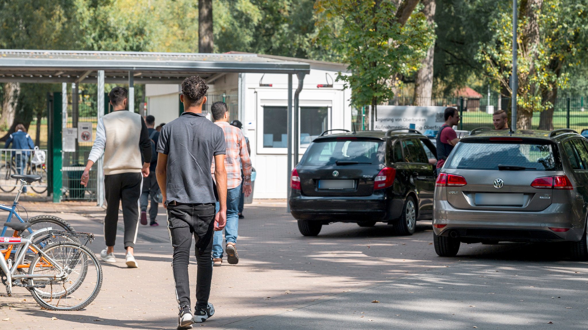 Mehrere Personen betreten die Flüchtlingsunterkunft Oberfranken durch den Haupteingang.