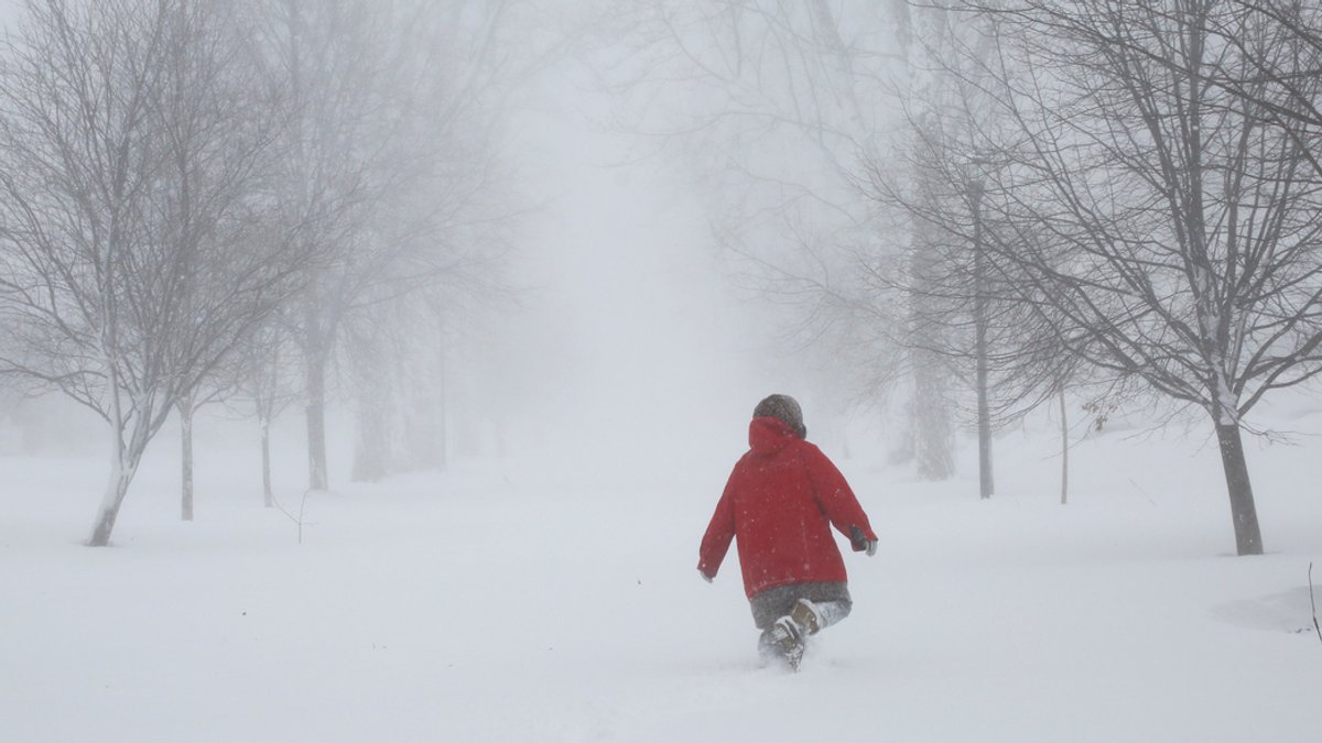 Ein Mensch läuft durch Schneemassen.