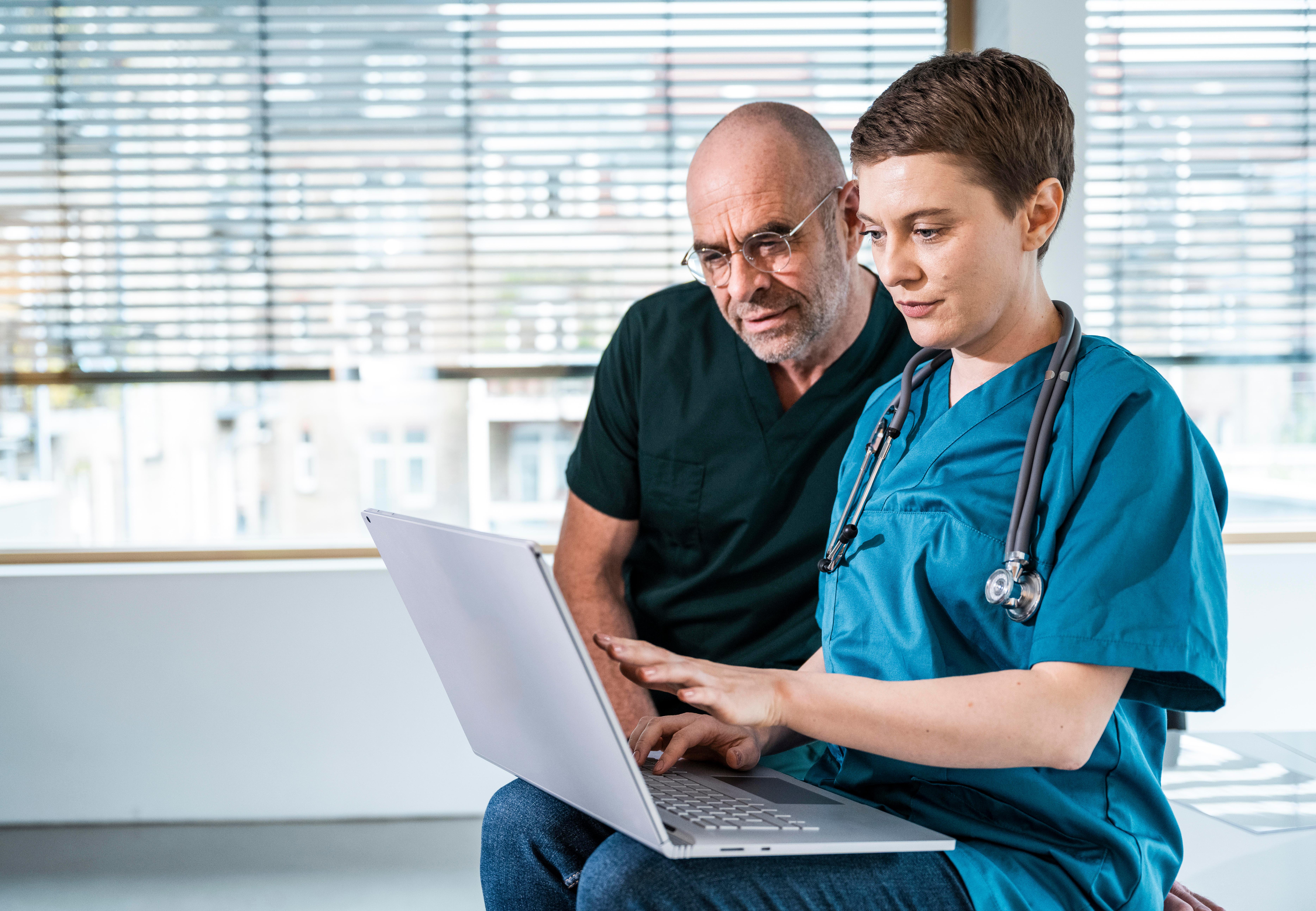 (Symbolbild) Eine Ärztin und ihr Patient besprechen am Laptop Befunde.