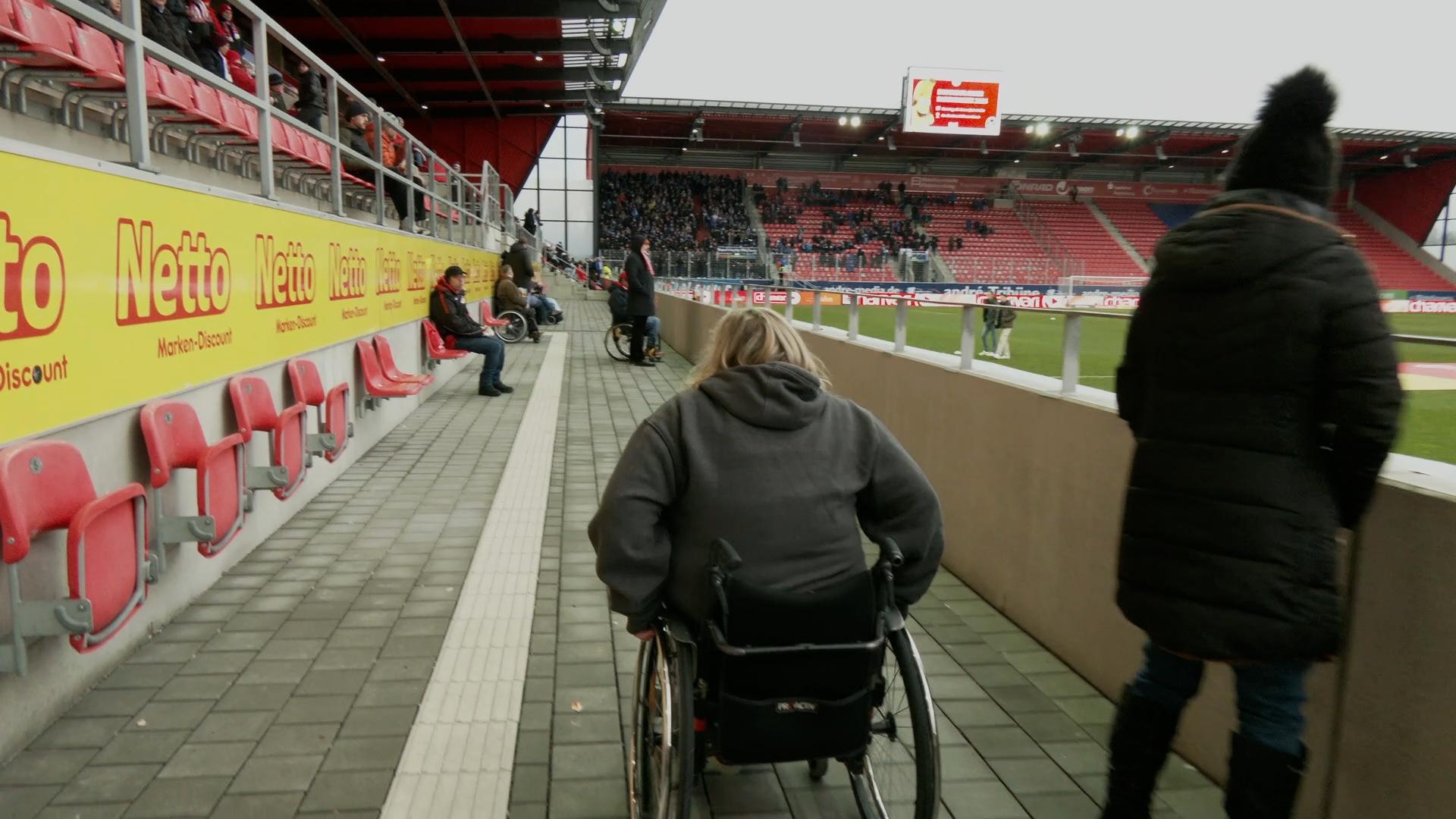 Eine Rollstuhlfahrerin ist im Jahnstadion in Regensburg unterwegs. 