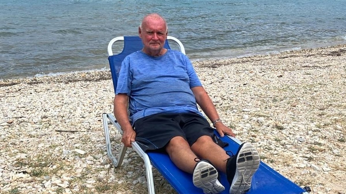Klaus Rehbock auf einer Liege am Strand in Griechenland - der 63-Jährige ist mittel- und obdachlos.