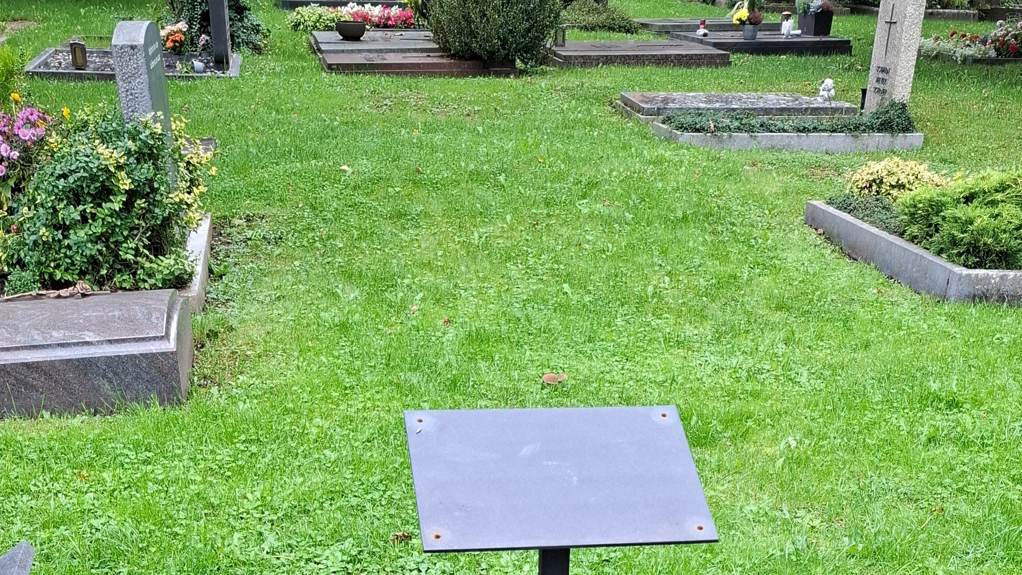 Eine Metallhalterung auf einem Friedhof.