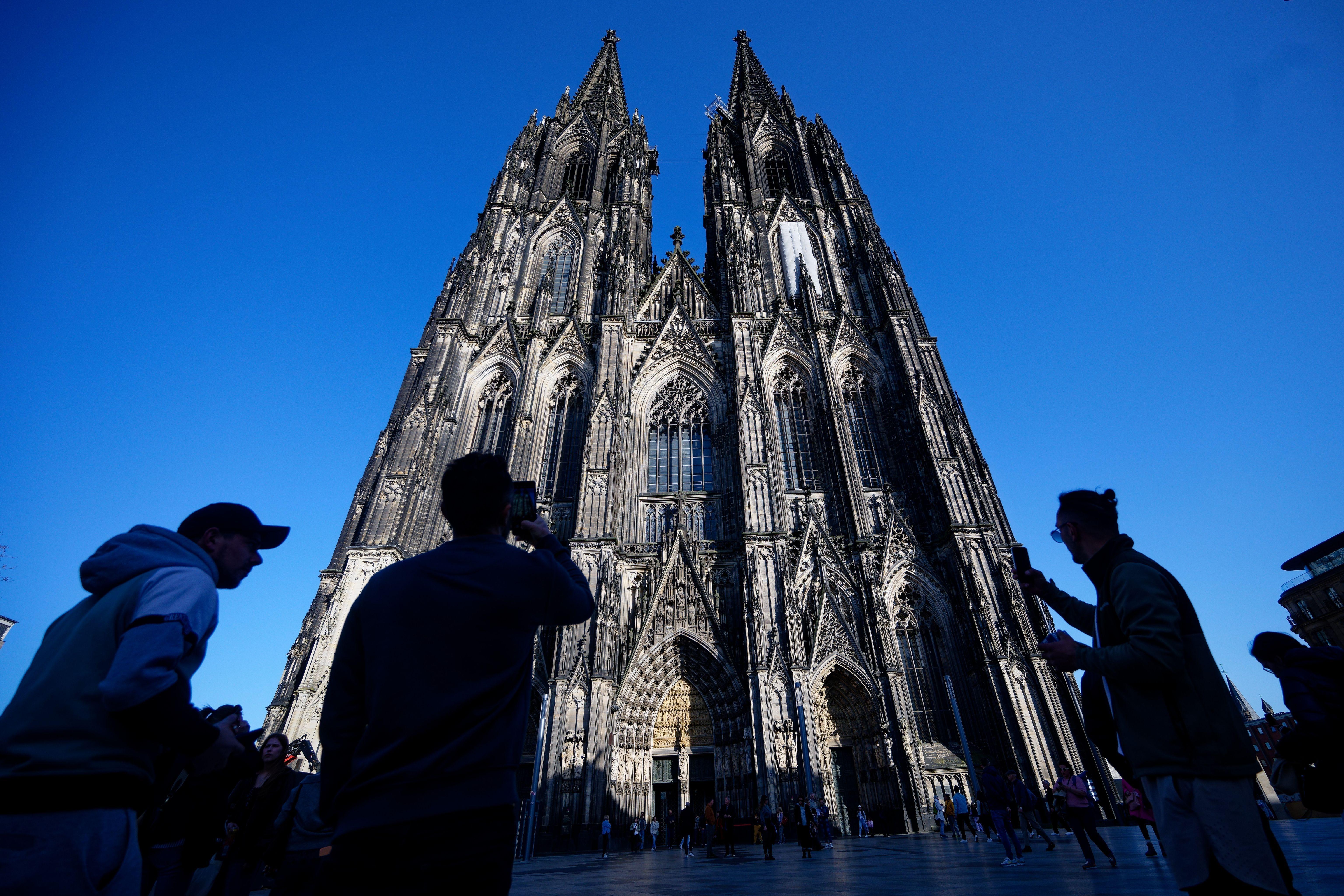 ARCHIV - 05.03.2026, Nordrhein-Westfalen, Köln: Touristen fotografieren den Kölner Dom. Der Kölner Dom wird Touristen in Zukunft Eintritt kosten. Damit sollen die gestiegenen Kosten für Pflege, Schutz und den laufenden Betrieb des Doms gedeckt werden, wie das Domkapitel mitteilte. (zu dpa: «Von Ablehnung bis Verständnis - Promis zum Dom-Eintritt») Foto: Henning Kaiser/dpa +++ dpa-Bildfunk +++