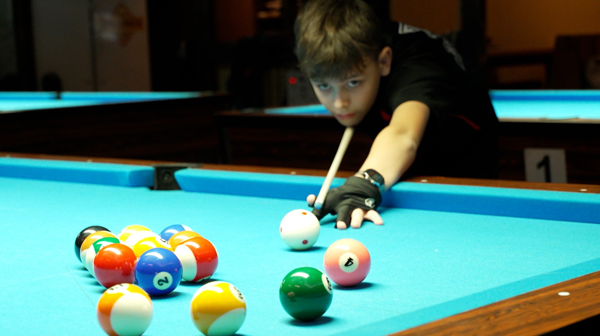 Ein Junge spielt Billard.